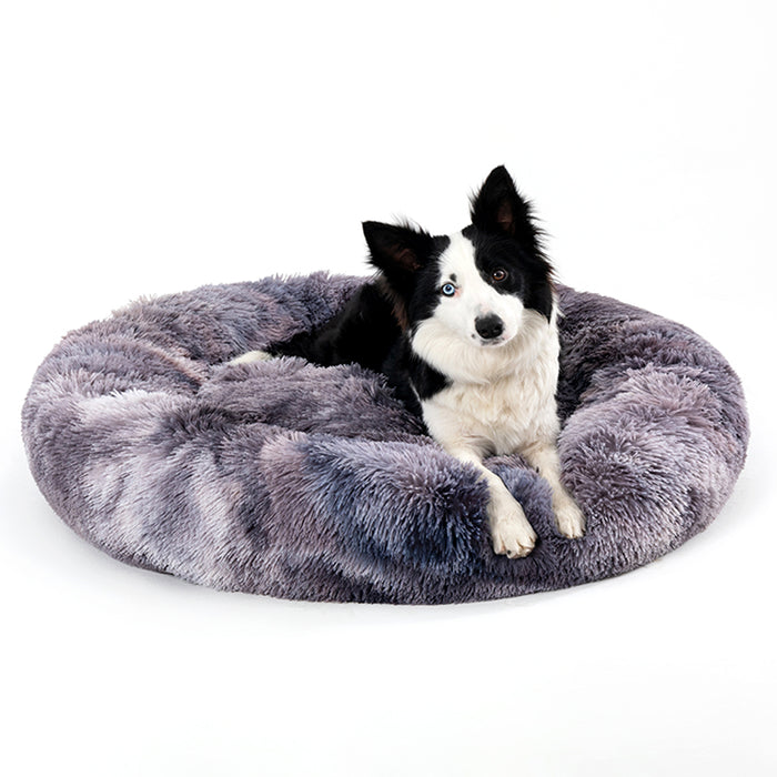 Dog lying in a fluffy grey Mara Calming Donut Bed